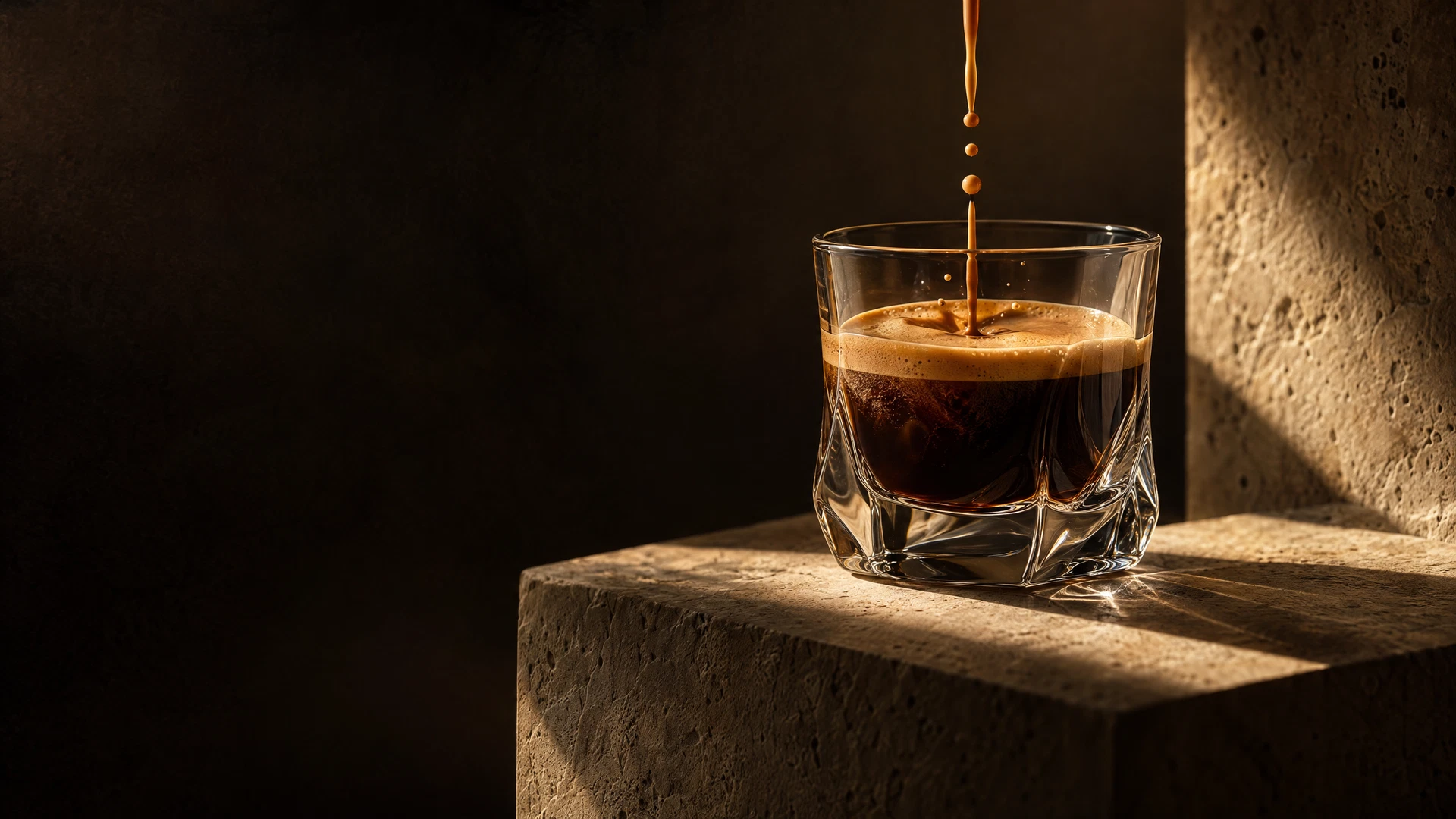 Espresso pouring into a glass in dramatic light